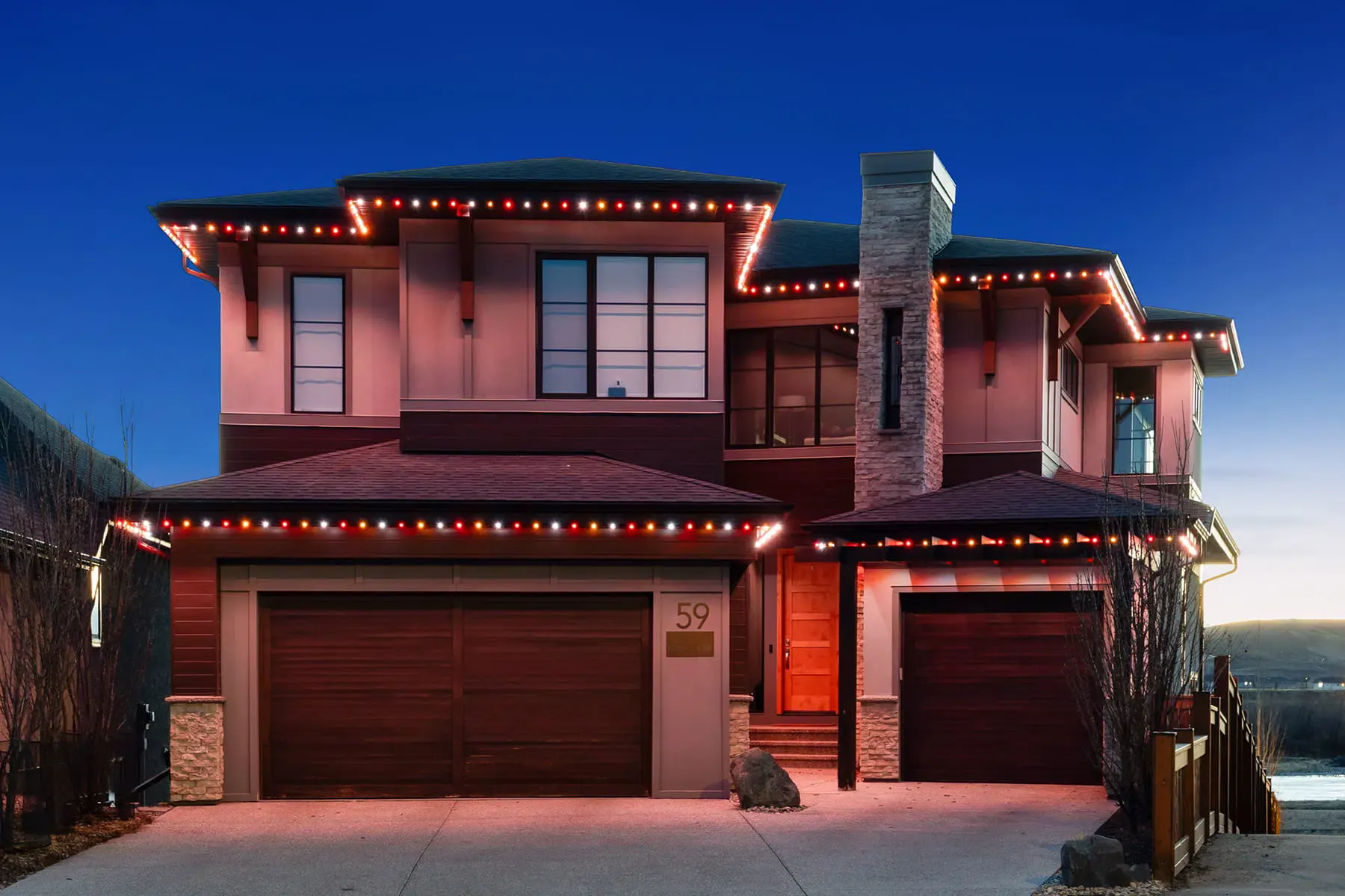 Two-storey home at dusk with permanent LED lights tracing every roofline